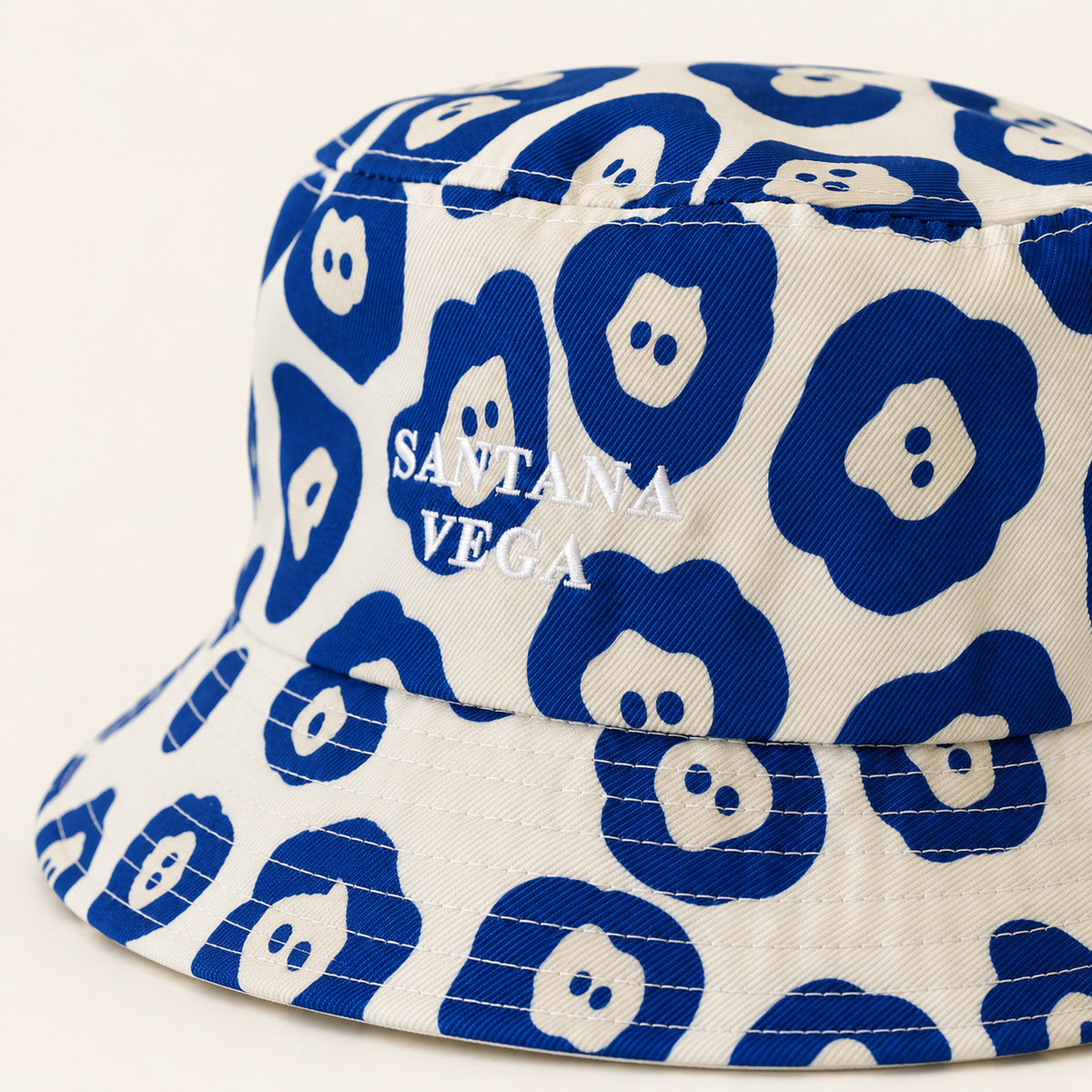 Nahaufnahme der Stickerei auf dem weiss-blauen Jaguar Bucket Hat von Santana Vega