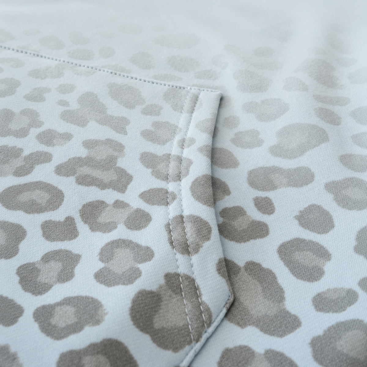 Detailaufnahme von Stoff und Leopardenmuster des hellblauen Santana Vega Hoodies