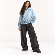 Stehendes Model im hellblauen Leopard Print Hoodie von Santana Vega