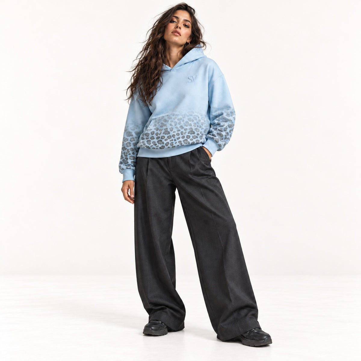 Stehendes Model im hellblauen Leopard Print Hoodie von Santana Vega